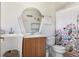 Bright bathroom featuring a unique mirror, wood vanity, and patterned shower curtain at 3214 W Rogers Ave, Tampa, FL 33611