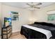 Comfortable bedroom with a ceiling fan, wood flooring, and neutral paint at 3214 W Rogers Ave, Tampa, FL 33611