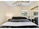 Serene bedroom with wood floors, ceiling fan, and a view of the backyard through a window at 3214 W Rogers Ave, Tampa, FL 33611