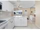 Open-concept kitchen with white cabinets, tiled floor, and view of the living room at 3214 W Rogers Ave, Tampa, FL 33611