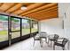 Enclosed patio with tile floors, tongue and groove ceiling, and table with seating at 3214 W Rogers Ave, Tampa, FL 33611