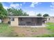 Back exterior of home with lawn, screened in porch, and sliding doors at 3214 W Rogers Ave, Tampa, FL 33611