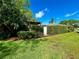 Secluded backyard retreat with lush landscaping, pergola, and privacy hedge creating a serene outdoor space at 3240 Sand Key Dr, Palm Harbor, FL 34684