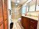 Bathroom featuring a glass-enclosed shower, wooden vanity, and neutral tile flooring at 3240 Sand Key Dr, Palm Harbor, FL 34684