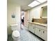 Bright bathroom featuring a vanity with granite countertop and colorful tiled floors at 3240 Sand Key Dr, Palm Harbor, FL 34684