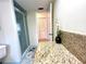 Cozy bathroom featuring a vanity with granite countertop and a shower with glass door at 3240 Sand Key Dr, Palm Harbor, FL 34684
