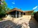 Back exterior with brick pavers, an enclosed porch, and a well-maintained backyard at 3240 Sand Key Dr, Palm Harbor, FL 34684