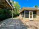 Back exterior with brick pavers, an enclosed porch, and a well-maintained backyard at 3240 Sand Key Dr, Palm Harbor, FL 34684