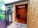 Shed with an open door, shelves and lighting, surrounded by a fence and landscaping at 3240 Sand Key Dr, Palm Harbor, FL 34684