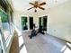 Bright sunroom with ample windows, ceiling fan, and sliding glass doors; perfect for relaxation or exercise at 3240 Sand Key Dr, Palm Harbor, FL 34684