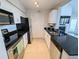Efficient kitchen with black granite countertops, stainless steel appliances, and white cabinetry at 3305 Haviland Ct # 301, Palm Harbor, FL 34684