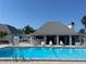 Community pool next to pool house with lounge chairs at 4237 Tamargo Dr # 4237, New Port Richey, FL 34652