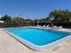 Community pool with lounge chairs, umbrellas, and an American flag at 4237 Tamargo Dr # 4237, New Port Richey, FL 34652