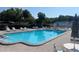 Community pool with lounge chairs and umbrellas on a sunny day at 4237 Tamargo Dr # 4237, New Port Richey, FL 34652
