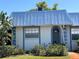 Charming home featuring a blue metal roof, stucco siding, an arched doorway, and neatly manicured landscaping at 4237 Tamargo Dr # 4237, New Port Richey, FL 34652