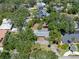 A high-angle shot of the house with lush green trees, a long drive-way and other houses nearby at 4315 W Azeele St, Tampa, FL 33609