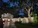 Beautifully lit exterior of a two-story home with mature trees and manicured landscaping at 5001 W Dickens Ave, Tampa, FL 33629