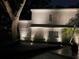 Nighttime view of a well-lit home featuring elegant landscaping and a charming brick facade at 5001 W Dickens Ave, Tampa, FL 33629