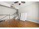 Open-concept living room with hardwood floors, a staircase, and white shutters at 5001 W Dickens Ave, Tampa, FL 33629