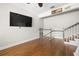Spacious living room with hardwood floors, a large TV, and staircase to the second floor at 5001 W Dickens Ave, Tampa, FL 33629