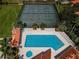 An aerial view shows the pool and the tennis courts, all surrounded by landscaping at 502 Hammock Pine Blvd # 502, Clearwater, FL 33761
