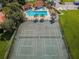 Aerial view of community tennis courts and pool surrounded by trees and landscaping at 502 Hammock Pine Blvd # 502, Clearwater, FL 33761