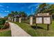 Community sign with community information board and lush landscaping at 502 Hammock Pine Blvd # 502, Clearwater, FL 33761