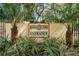 Community entrance sign nestled amongst meticulously maintained tropical landscaping at 502 Hammock Pine Blvd # 502, Clearwater, FL 33761