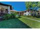 Exterior of building with green grass, walkway, mature plants and trees at 502 Hammock Pine Blvd # 502, Clearwater, FL 33761