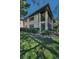 Charming condo exterior featuring a screened lanai, lush landscaping, and a well-maintained lawn at 502 Hammock Pine Blvd # 502, Clearwater, FL 33761