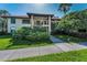 Condo building with sidewalk and manicured tropical landscaping at 502 Hammock Pine Blvd # 502, Clearwater, FL 33761