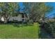 Condo featuring a screened lanai, balcony, lush landscaping, mature trees, and well-maintained lawn at 502 Hammock Pine Blvd # 502, Clearwater, FL 33761