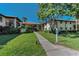 Well-maintained condo building with lush landscaping and a sidewalk leading to the entrance at 502 Hammock Pine Blvd # 502, Clearwater, FL 33761