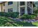 Charming condo exterior featuring a screened lanai, lush landscaping, and a well-maintained lawn at 502 Hammock Pine Blvd # 502, Clearwater, FL 33761