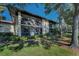 Condo featuring a screened lanai, balcony, lush landscaping, mature trees, and well-maintained lawn at 502 Hammock Pine Blvd # 502, Clearwater, FL 33761