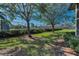 Well-maintained community grounds with mature trees, lush landscaping, and a tennis court in the background at 502 Hammock Pine Blvd # 502, Clearwater, FL 33761