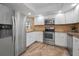 A modern kitchen with stainless steel appliances, white cabinets, and granite countertops at 502 Hammock Pine Blvd # 502, Clearwater, FL 33761