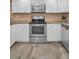 A modern kitchen with stainless steel appliances, white cabinets, and granite countertops at 502 Hammock Pine Blvd # 502, Clearwater, FL 33761