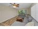 A cozy living room features a comfortable gray sectional sofa and views of the well-manicured backyard at 502 Hammock Pine Blvd # 502, Clearwater, FL 33761