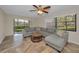 A cozy living room features a comfortable gray sectional sofa and views of the well-manicured backyard at 502 Hammock Pine Blvd # 502, Clearwater, FL 33761