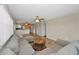 Bright open-concept living room featuring tile floors, a ceiling fan, and a comfortable gray sectional sofa at 502 Hammock Pine Blvd # 502, Clearwater, FL 33761