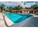 Community pool area with ample seating, lush landscaping, and lounge chairs at 502 Hammock Pine Blvd # 502, Clearwater, FL 33761