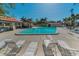 Community pool featuring a spacious deck area with lounge chairs, cabana and mature landscaping at 502 Hammock Pine Blvd # 502, Clearwater, FL 33761