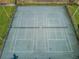 Aerial view of tennis courts with green surface, enclosed by fencing at 502 Hammock Pine Blvd # 502, Clearwater, FL 33761