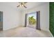 A bright, empty bedroom with neutral tiling and an exterior door at 531 Bimini Bay Blvd, Apollo Beach, FL 33572