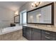 Bright bathroom featuring a soaking tub, dark wood cabinets and granite countertops at 5316 Candler View Dr, Lithia, FL 33547