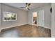 Bedroom featuring hardwood floors, ceiling fan, window and view of the attached bathroom at 5316 Candler View Dr, Lithia, FL 33547