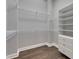 Walk-in closet featuring wood floors and ample shelf and drawer storage at 5316 Candler View Dr, Lithia, FL 33547