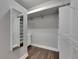 Walk-in closet featuring wood floors and ample shelf storage, drawers, and hanging racks at 5316 Candler View Dr, Lithia, FL 33547