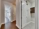 Hallway with hardwood flooring leading to rooms, including a laundry area with cabinet and shelving at 5316 Candler View Dr, Lithia, FL 33547